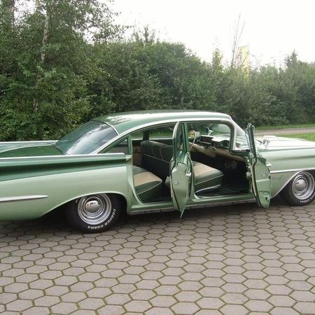 Oldsmobile 1959 von der Seite mit offenen Türen.