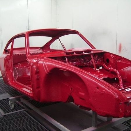 Porsche 911 Grundgerüst mit roter Lackierung von der Seite.
