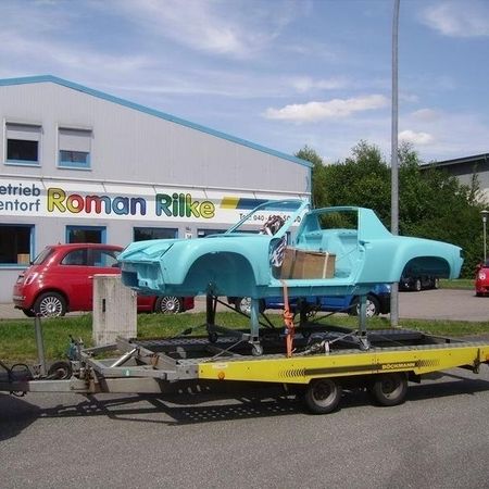 Porsche 914 im lackierten Zustand in hellblau auf einen Fahrzeuganhänger.