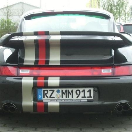 Porsche 933 in schwarz mit weißen und roten Steifen über den Heck.