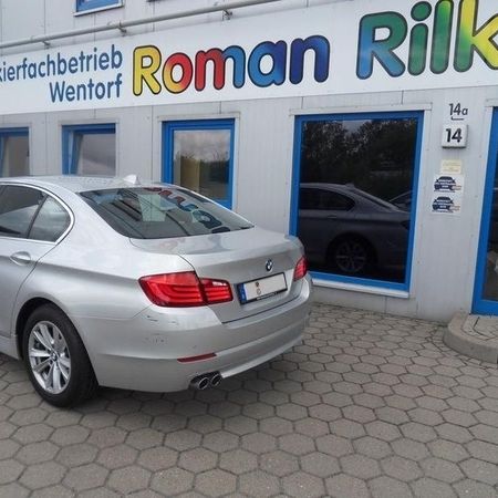 Aufnahme eines silbernen BMW ohne Schramme vor dem Firmengebäude von Roman Rilke.