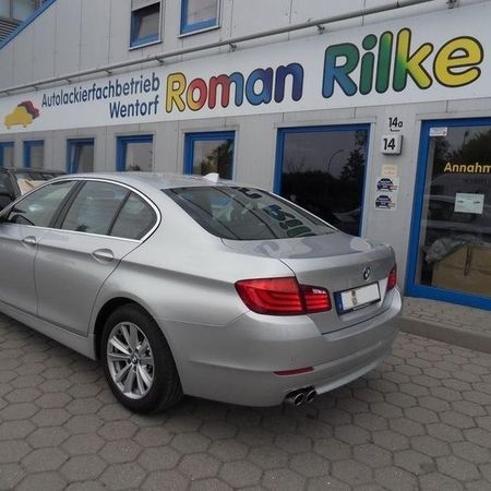 Aufnahme eines silbernen BMW ohne Schramme vor dem Firmengebäude von Roman Rilke.
